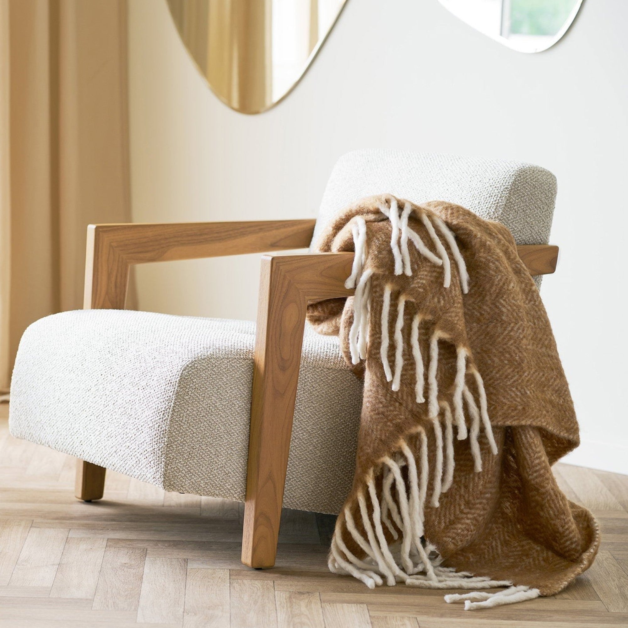 Kayu Living Carmel Plaid tan wool-blend throw with white fringe draped over a modern upholstered armchair