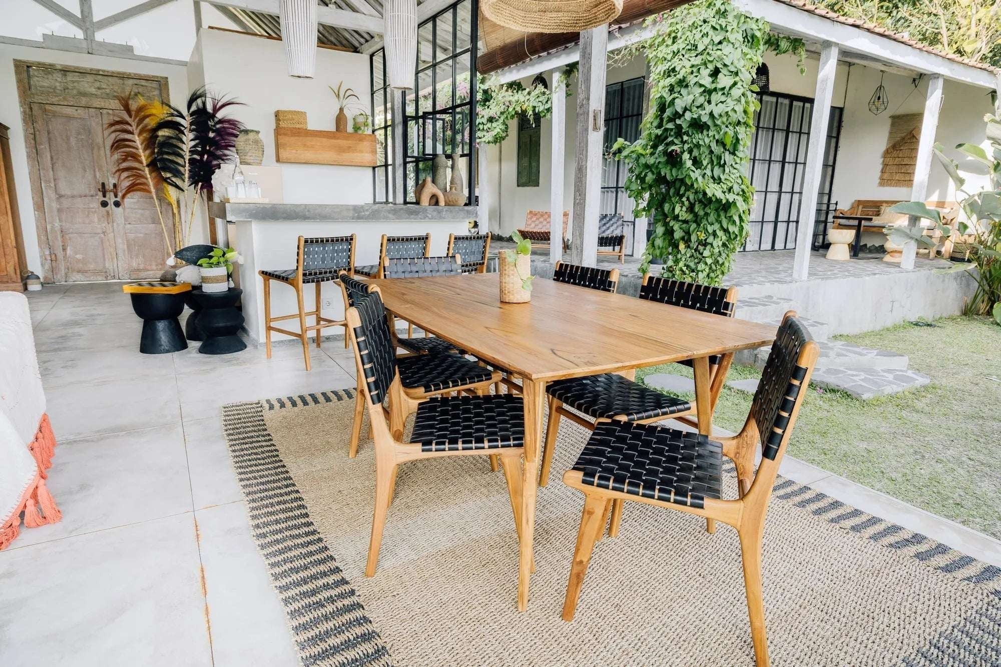Kayu Living Umalas counter stool with black woven leather seat and teak frame, ideal for kitchen counters or bar areas.