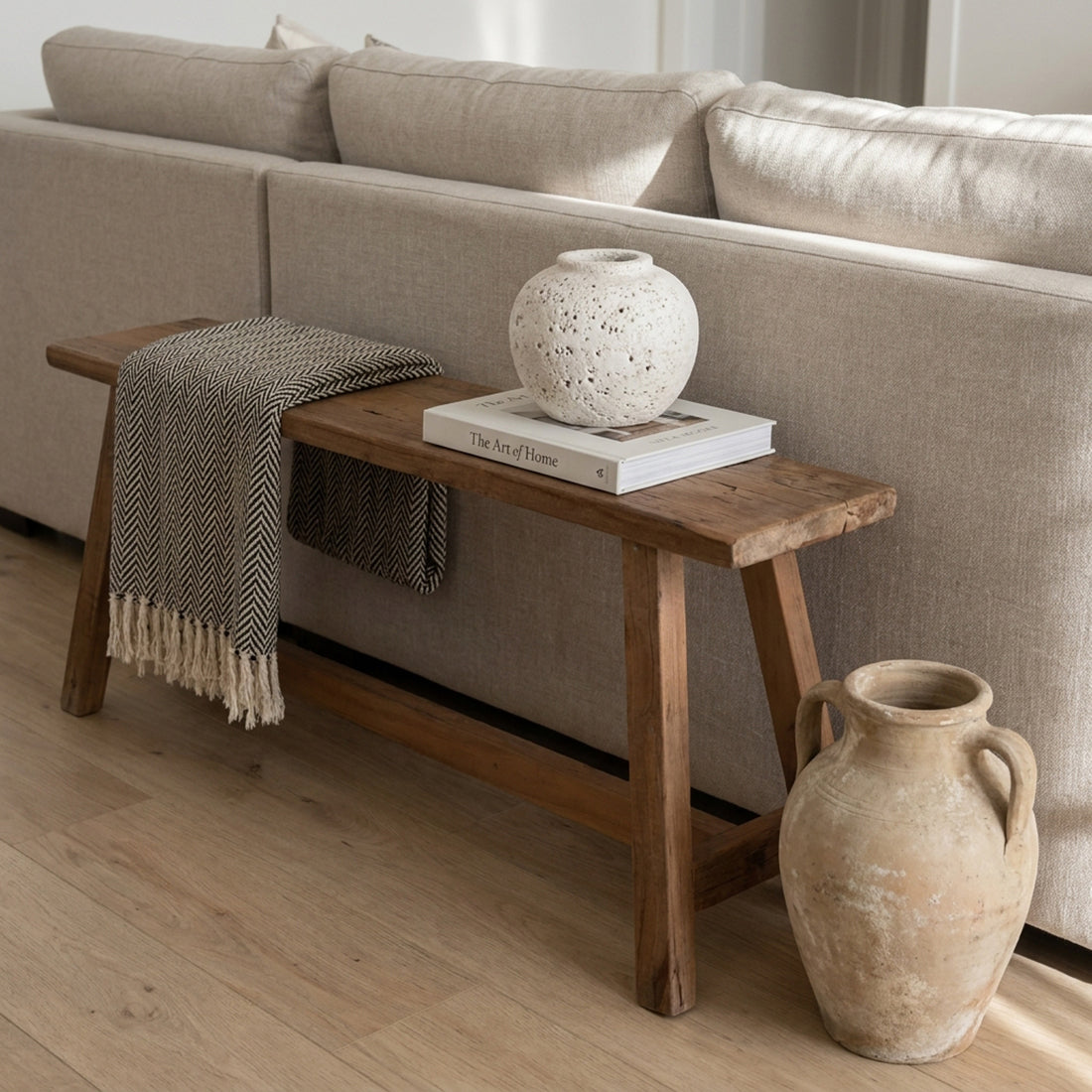Kayu Living Farmwood 115cm reclaimed wood bench styled with a throw blanket and decorative vases behind a sofa