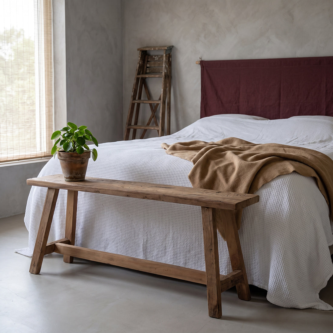 Kayu Living Farmwood 115cm reclaimed wood bench with natural grain and knots at the foot of a bed in a rustic bedroom