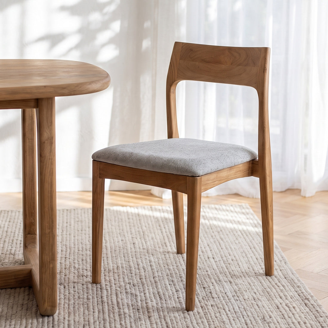 Kayu Living Freya teak dining chair with a light green fabric seat, featuring a minimalist wooden frame design.