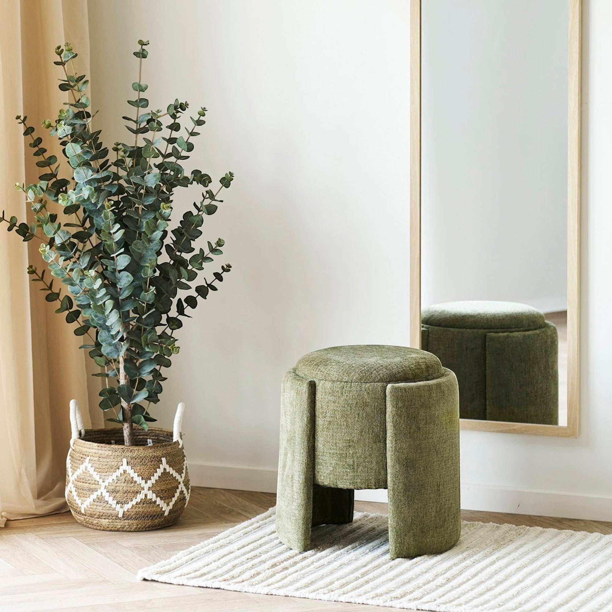 Kayu Living green round pouf with fabric upholstery and unique panelled legs, perfect for modern living rooms.