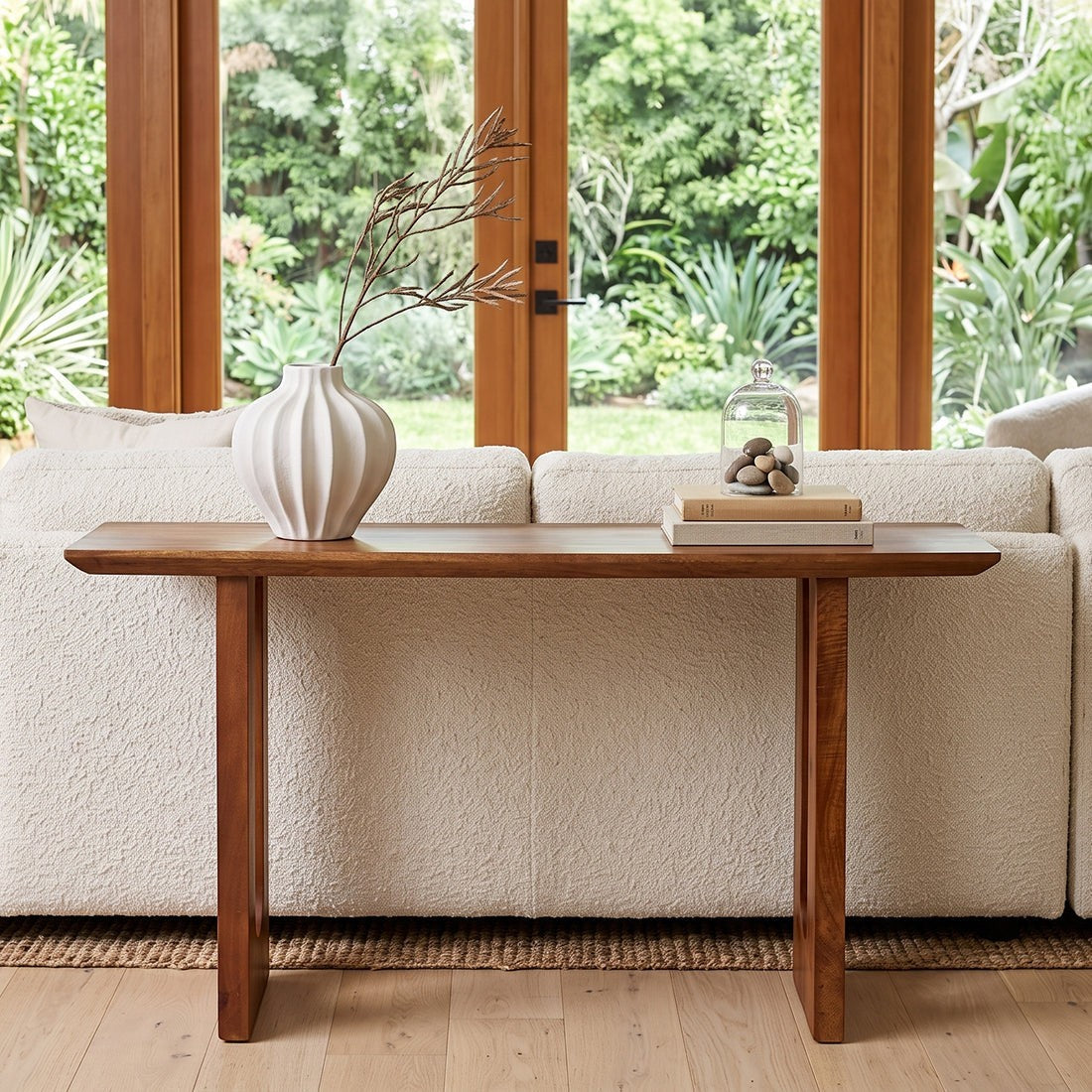 Kayu Living mango wood console table with chamfered edges placed behind a cream sofa in a bright living room