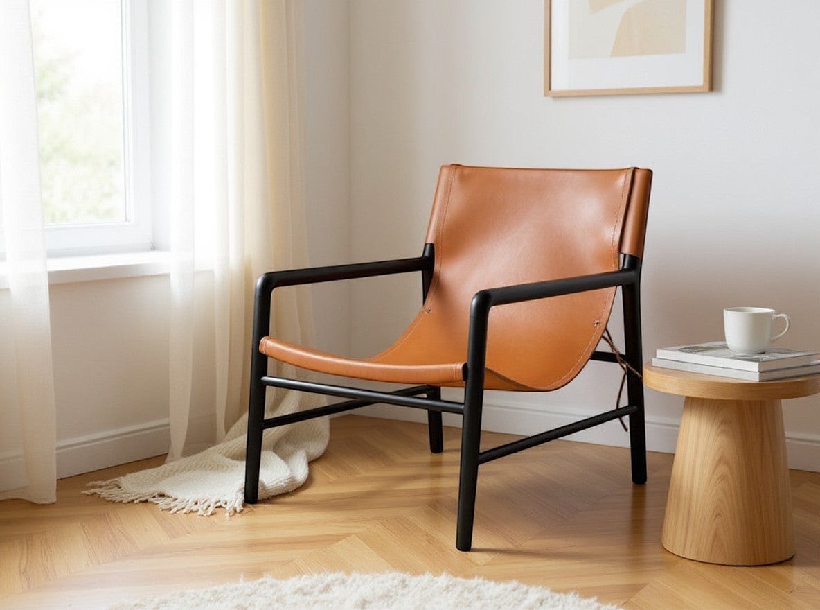 Kayu Living Marita lounge chair in cognac leather with black frame. Modern armchair for living room.