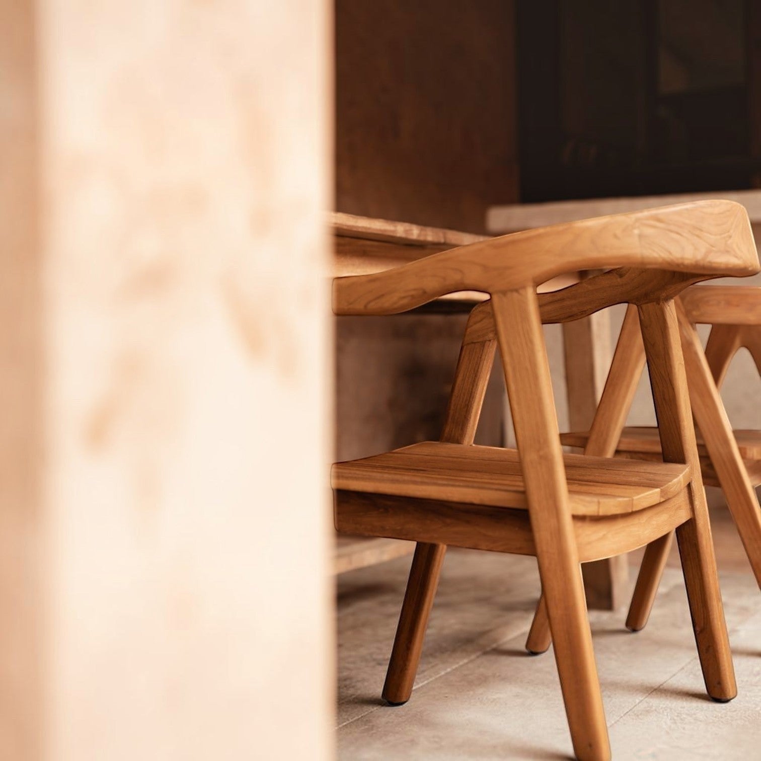 Kayu Living Nihi Oka dining chair made of natural Indonesian teak with sculpted curved back and clean lines.