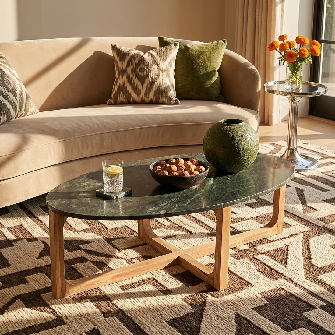 Kayu Living oval coffee table with a green marble top and sustainable mango wood base in a sunlit living room.