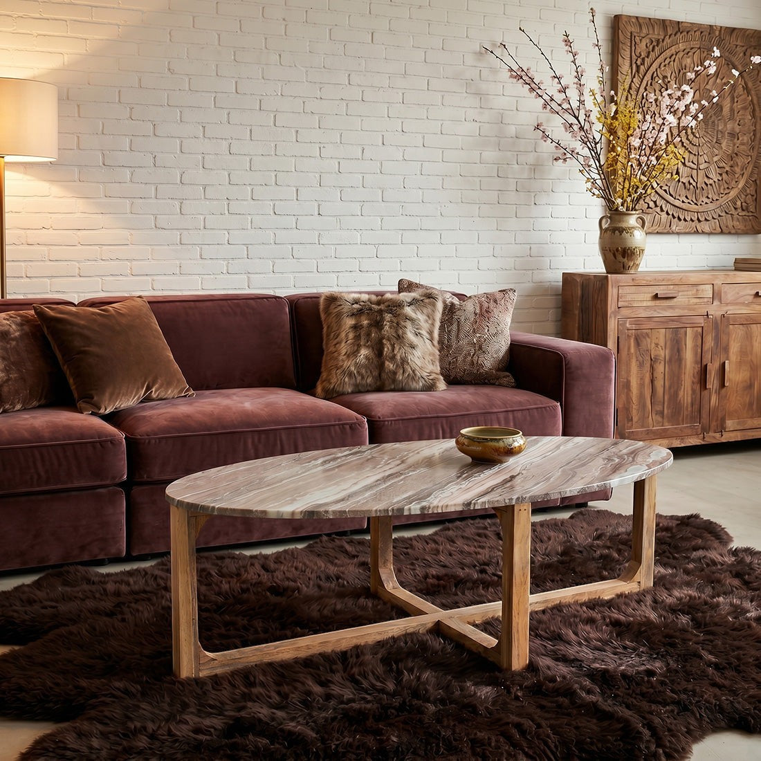 Kayu Living oval Fantasy Brown marble coffee table with wood base in a cozy living room with a velvet sofa
