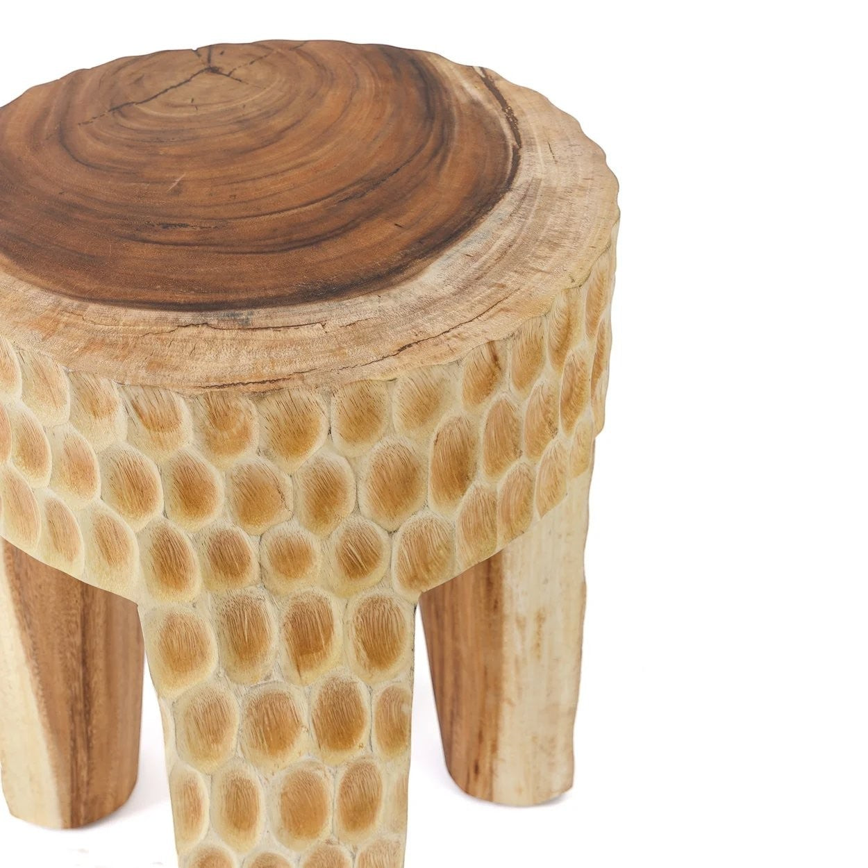 Kayu Living Paramo Stool handcrafted from natural suar wood with a textured carved base and three sturdy legs.