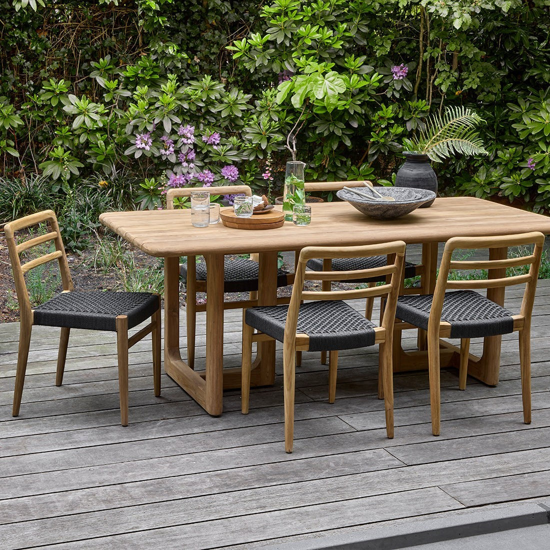 Kayu Living Primavera 240cm FSC recycled teak garden table with rounded edges and U-shaped legs on a wooden deck.