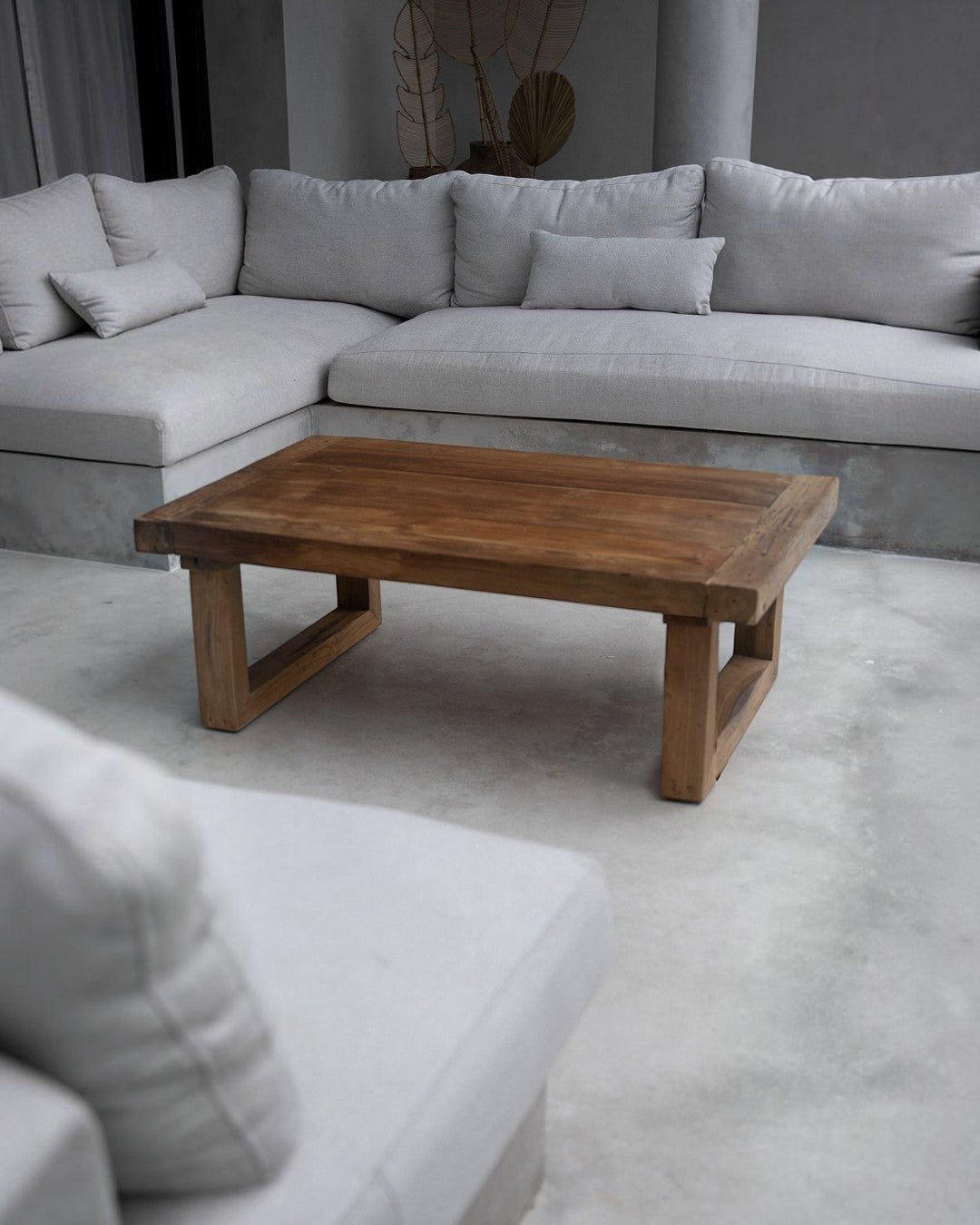 Kayu Living reclaimed teak coffee table with a natural wood finish, set in a modern living room with a grey sofa.