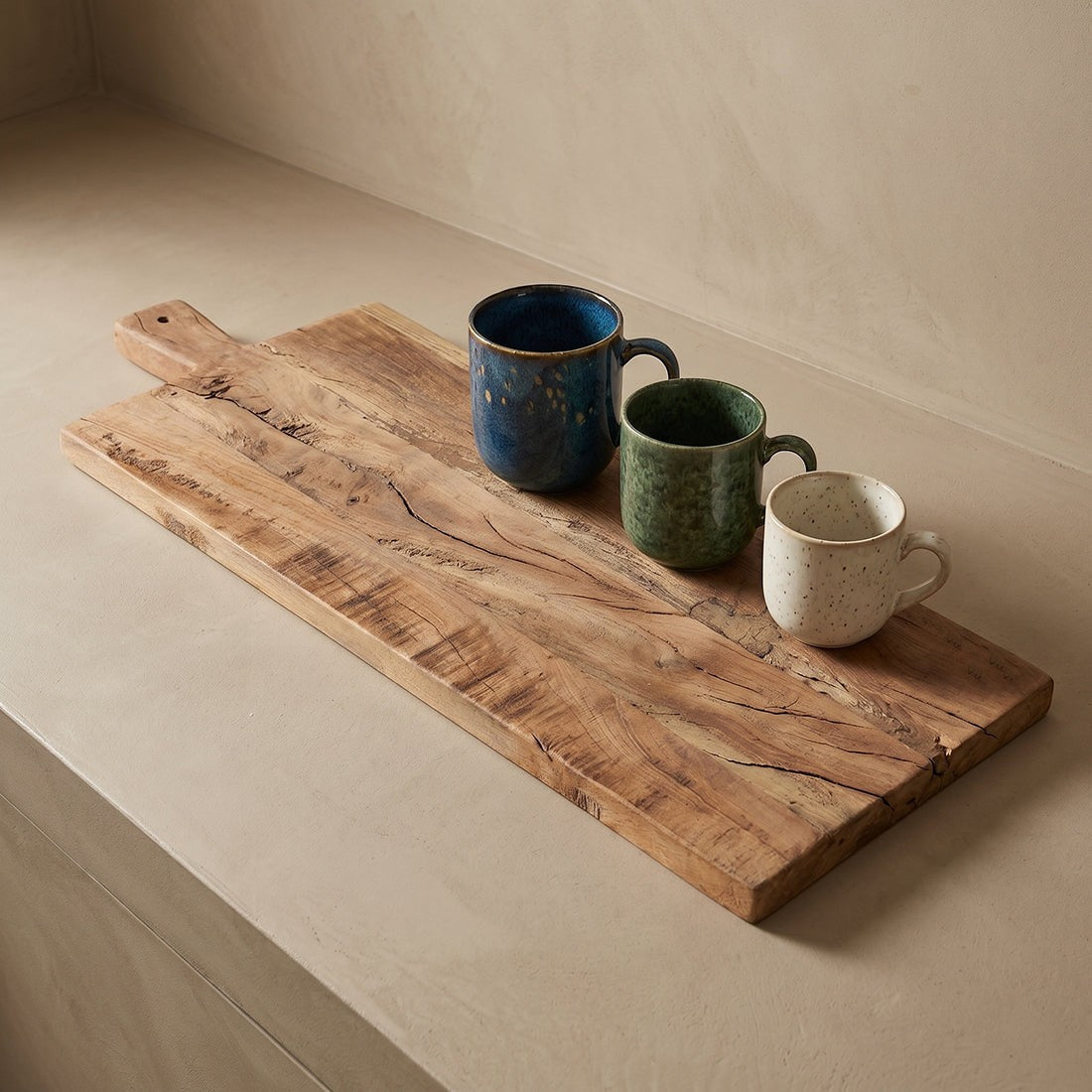Kayu Living 60cm reclaimed wood charcuterie board with natural grain and knots, featuring three rustic ceramic mugs.