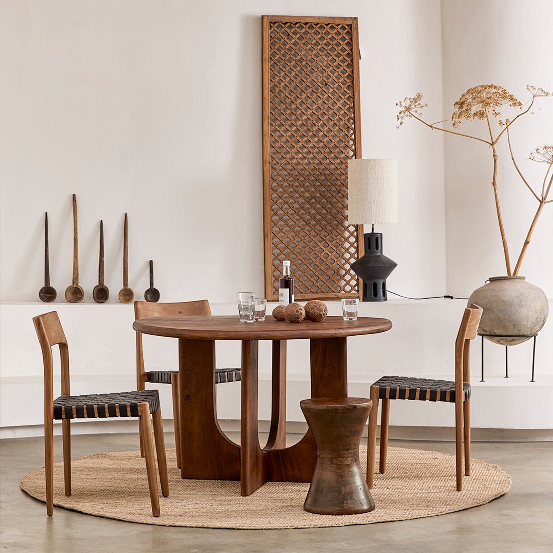 Kayu Living round Bullnose Coliseo dining table in solid mango wood with a sturdy cross-shaped base in a dining room