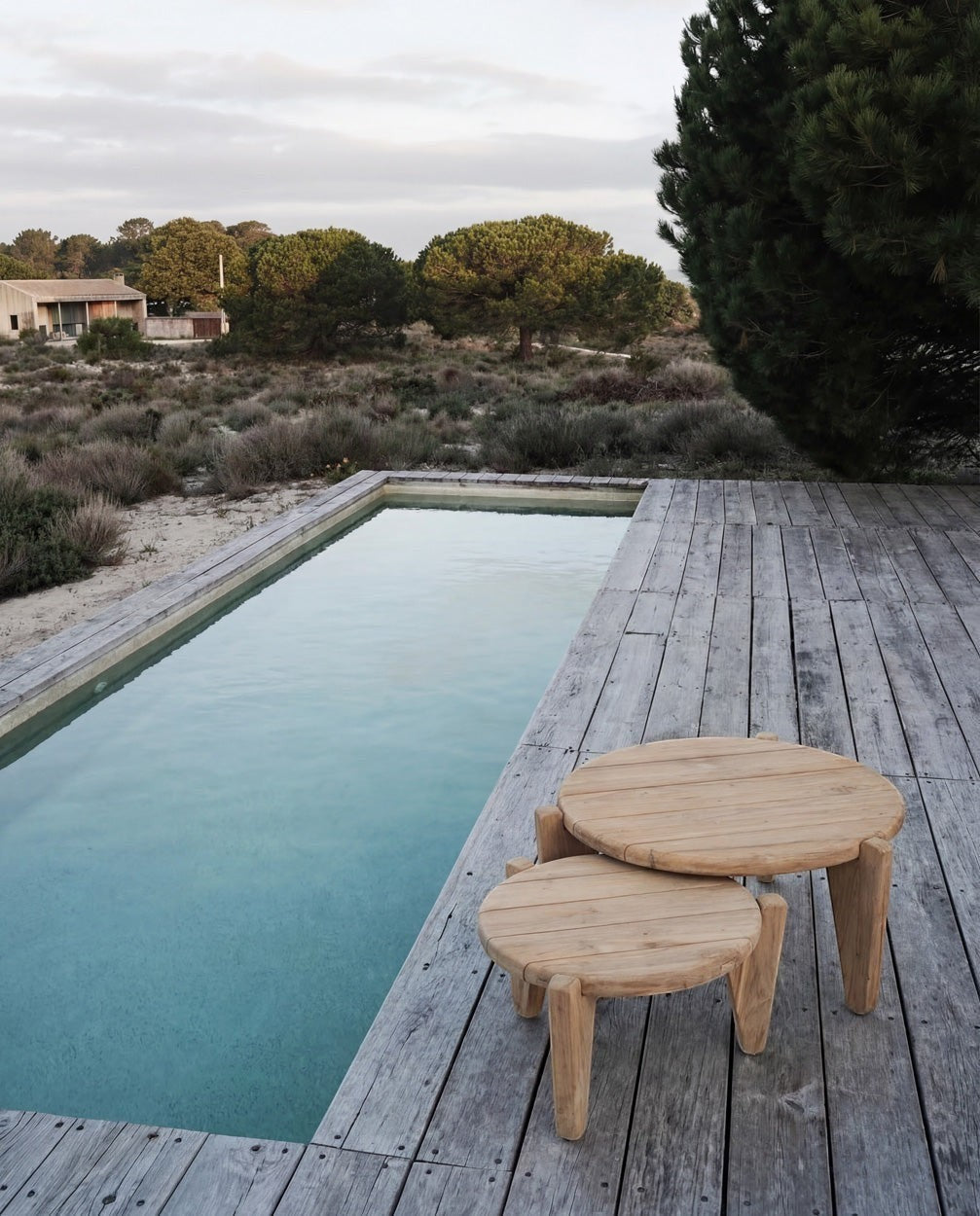 Kayu Living Seseh outdoor coffee table set crafted from reclaimed teak, featuring a distinctive three-leg silhouette and natural grain.