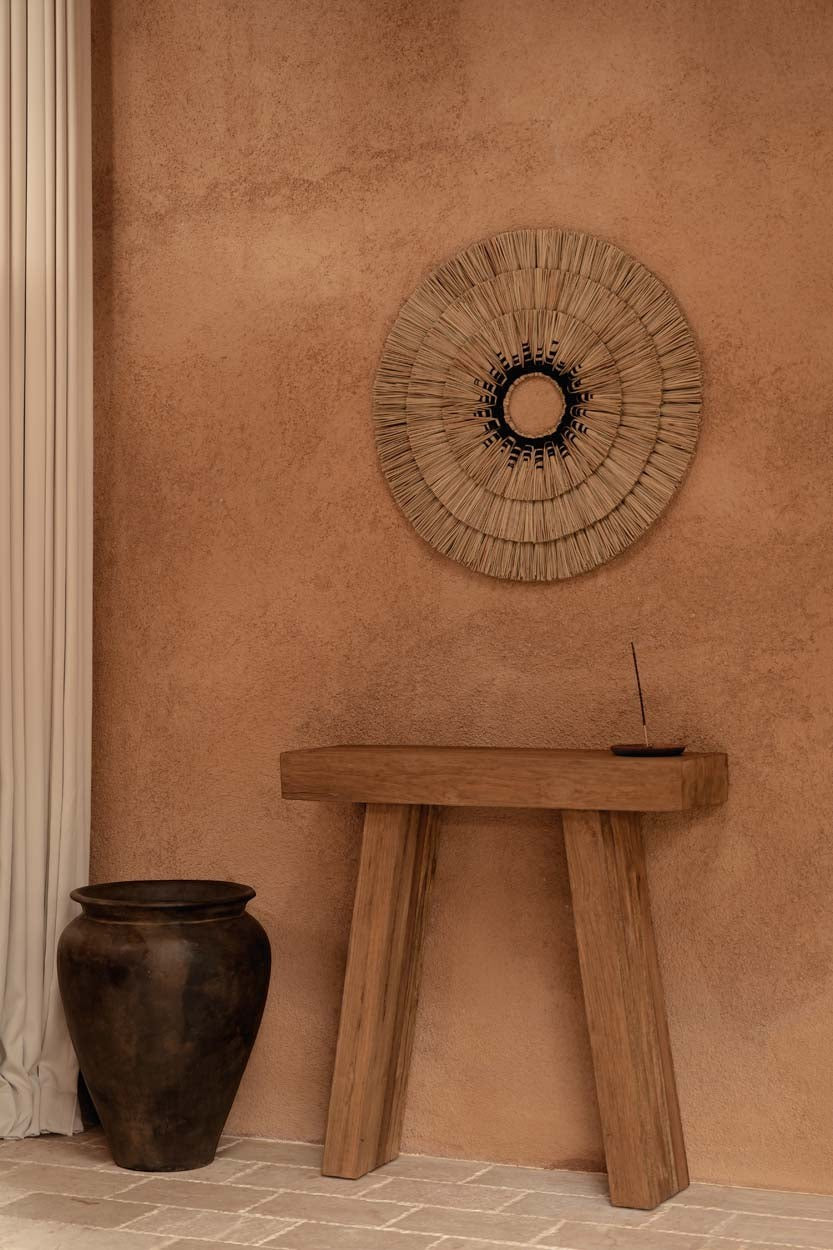 Kayu Living Stance Console table in natural teak wood with clean angles against a textured terracotta wall.