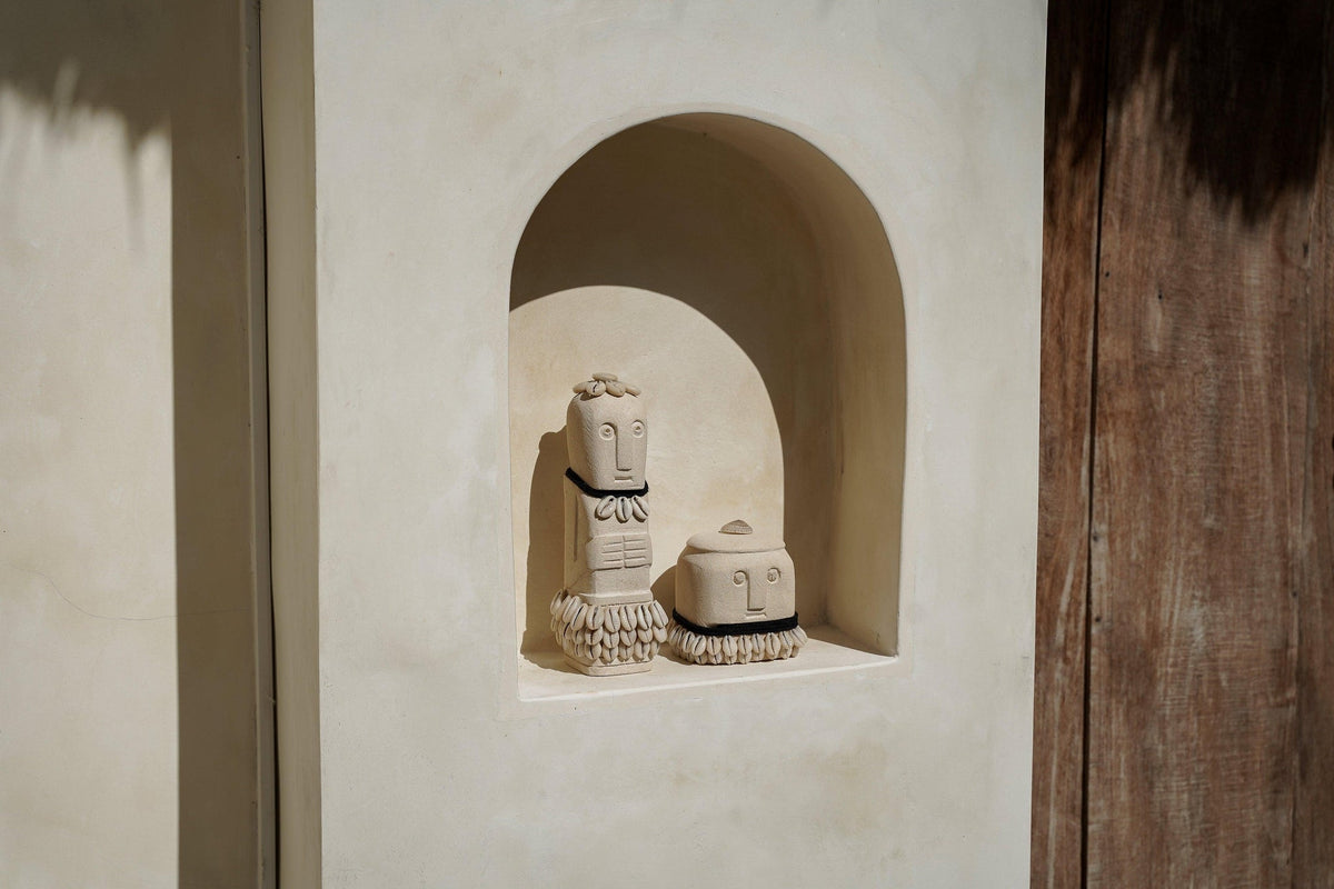 Kayu Living handmade natural stone figurines with boho details displayed in a beige arched wall niche