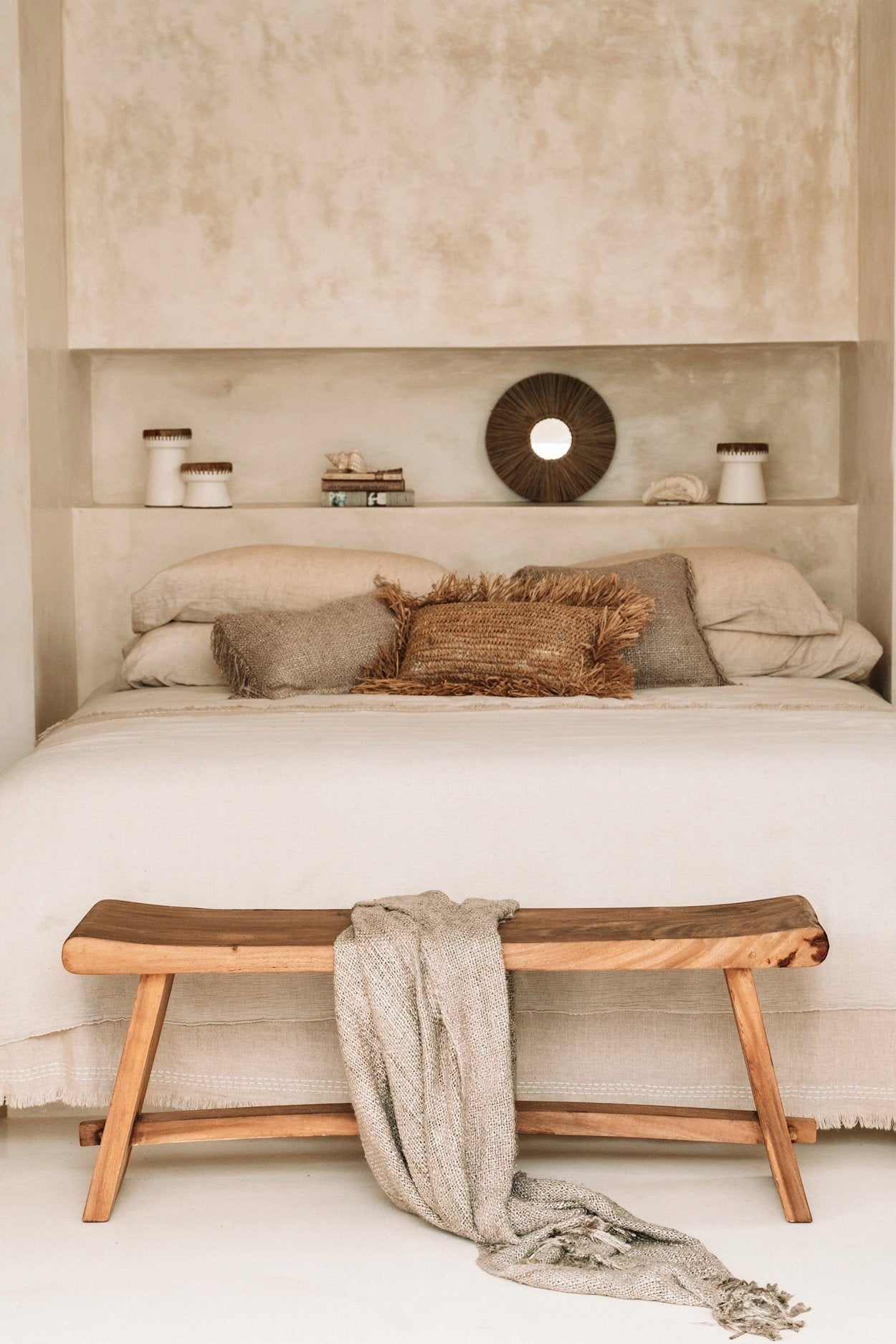 Kayu Living 120 cm handmade Suar wood bench with natural grain, draped with a textured throw in a neutral bedroom.