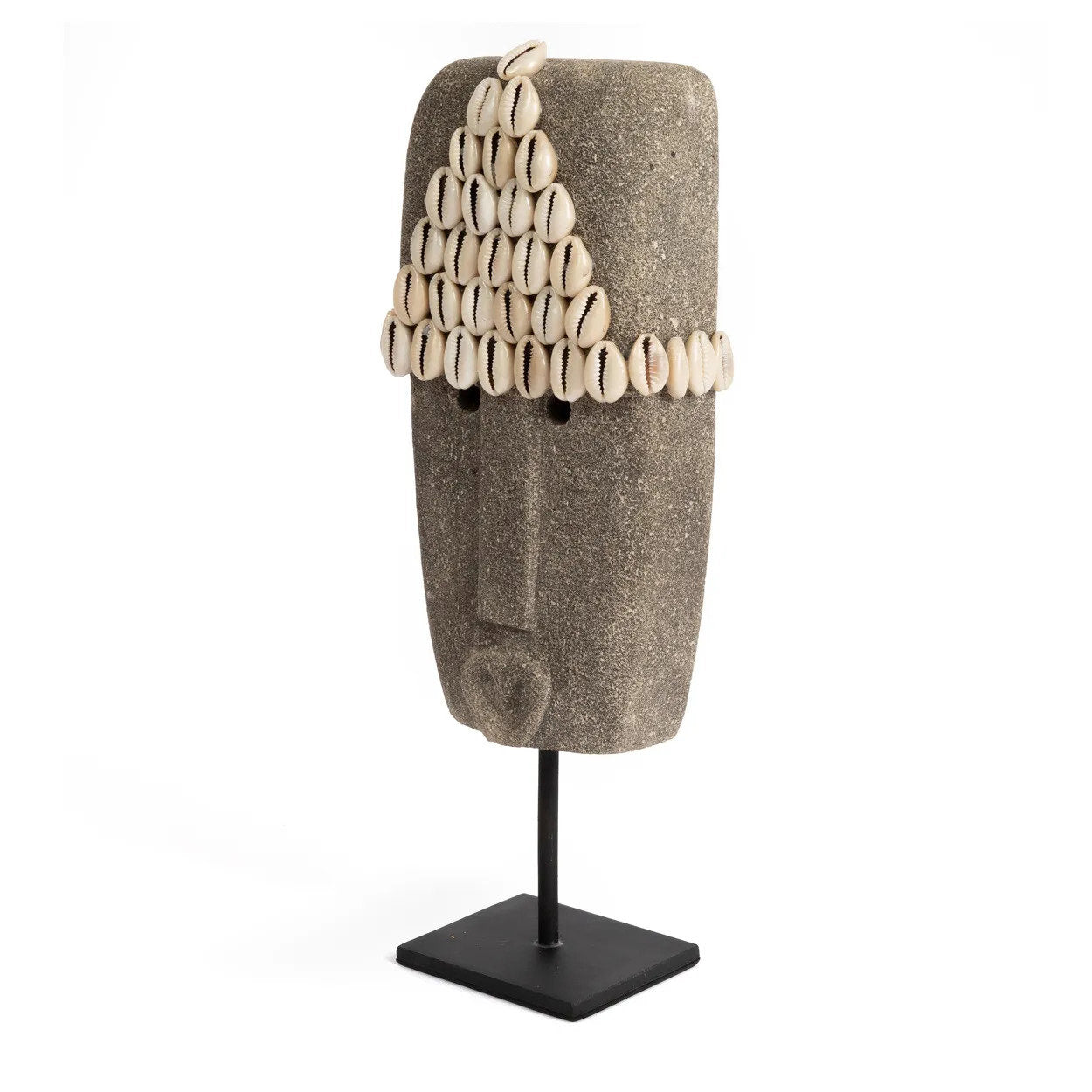 Kayu Living hand-carved grey sandstone Sumba statue featuring a cowrie shell headdress on a black metal stand.