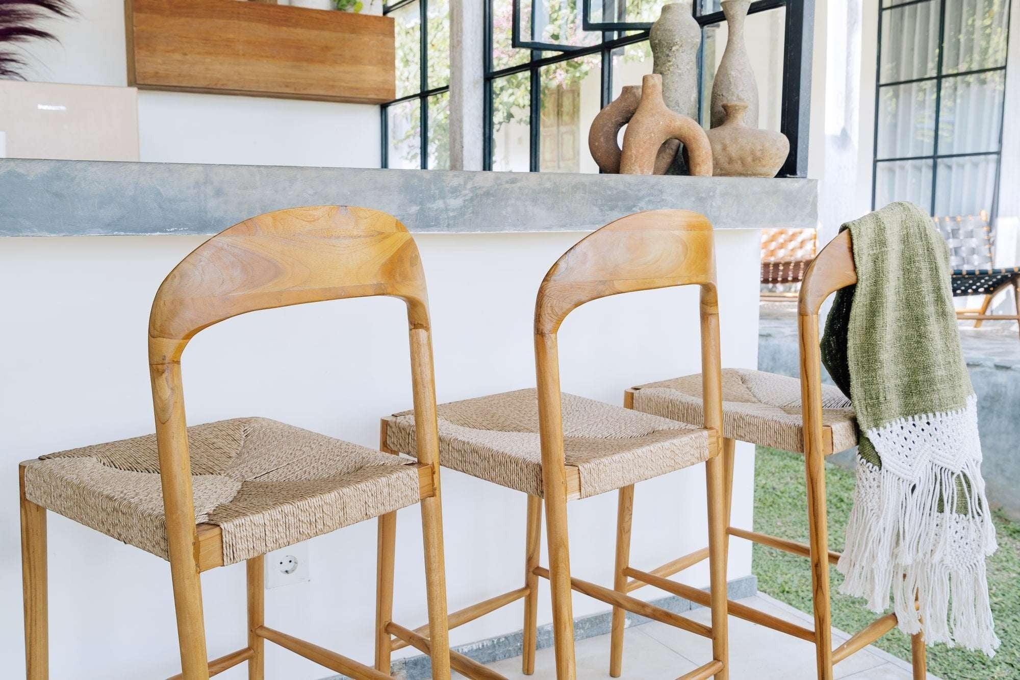 Kayu Living Cemagi teak and natural rope counter stool with curved backrest. Ideal for kitchens and bars.