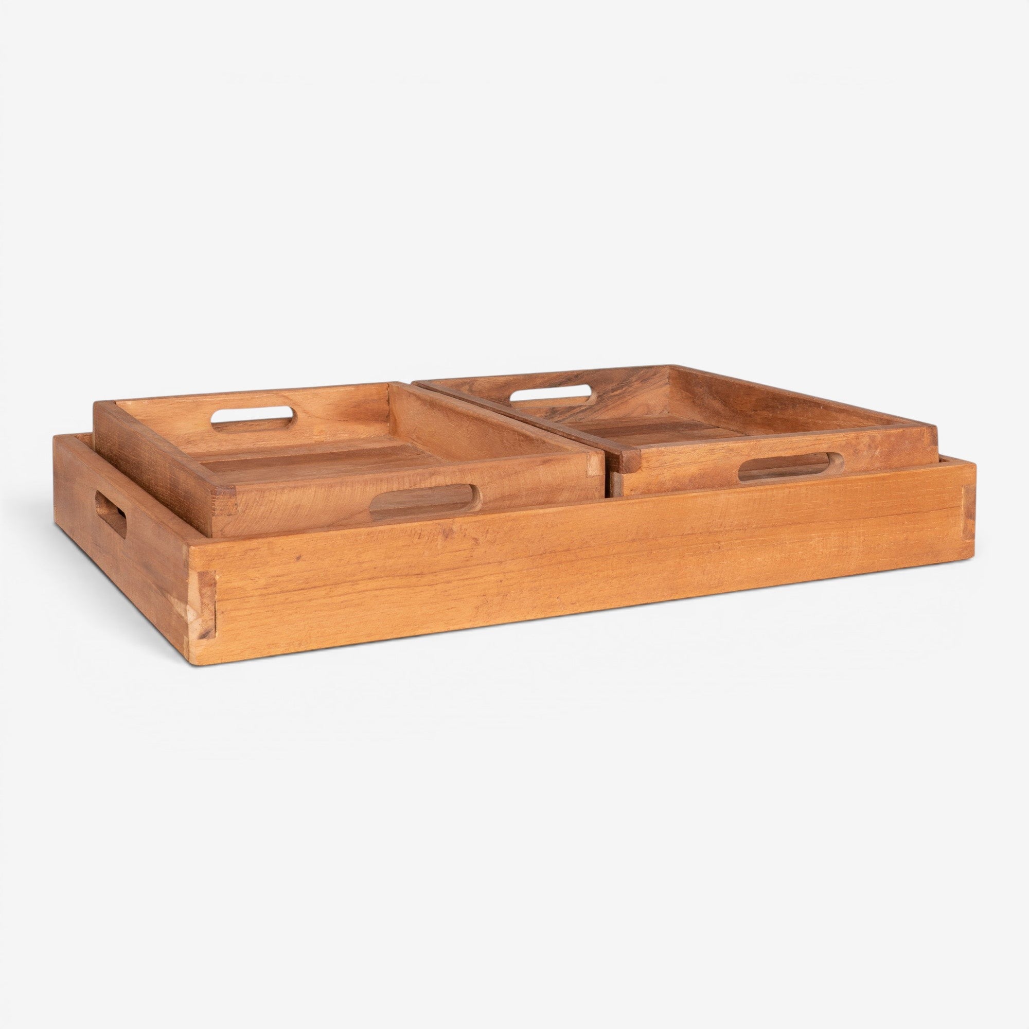 Kayu Living set of 3 natural teak serving trays with cut-out handles and warm grain finish.