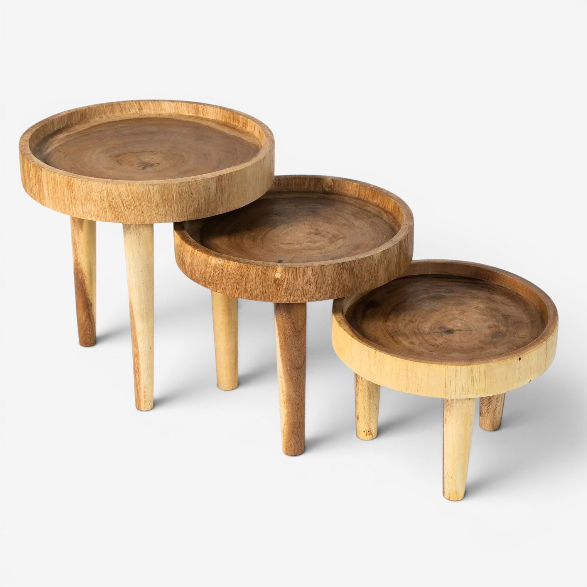 Kayu Living Ulu side tables in natural suar wood, featuring three sizes with distinctive grain patterns and three-legged bases.