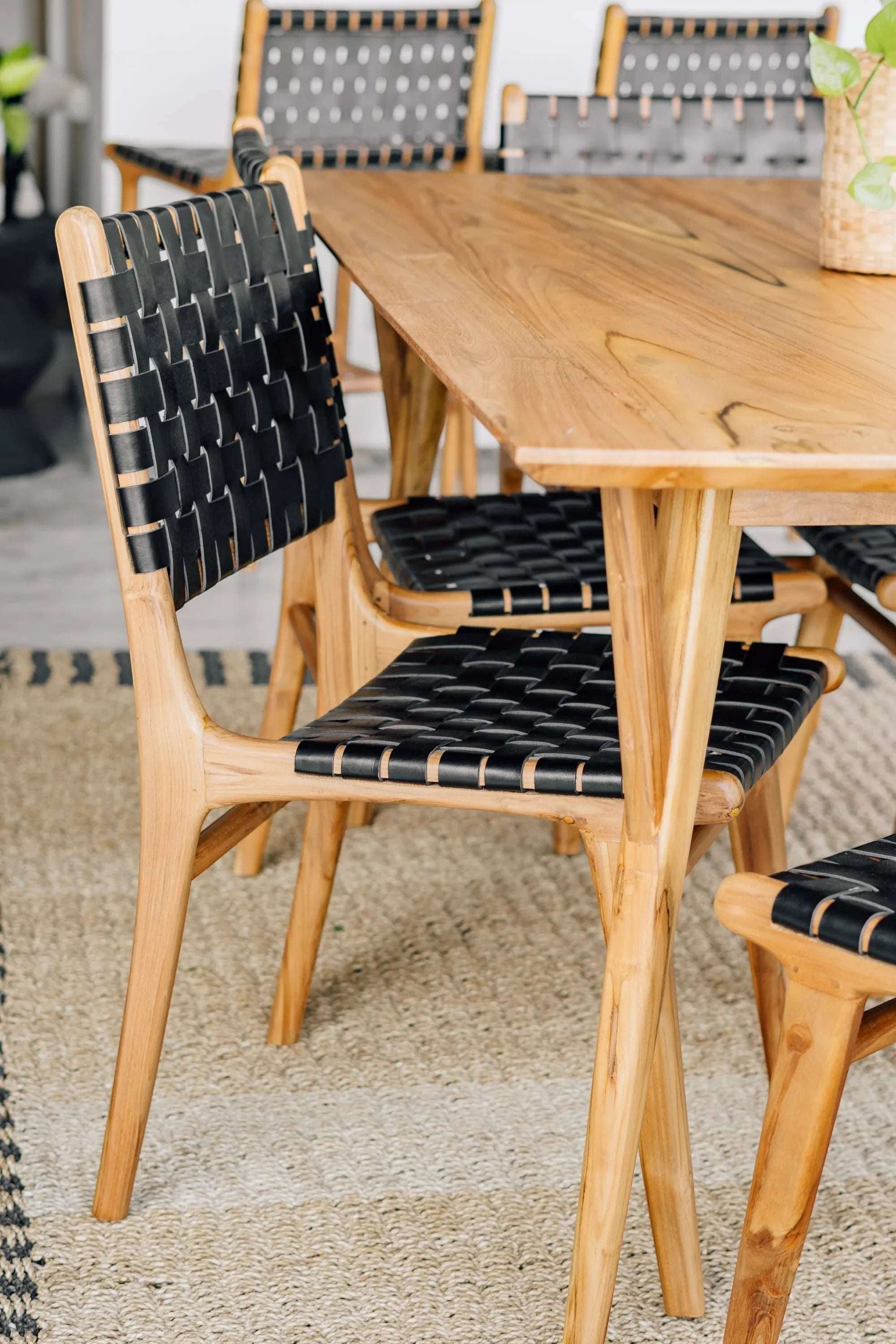 Kayu Living Umalas dining chair with hand-woven black leather seat and teak frame. Modern design, comfortable and durable.