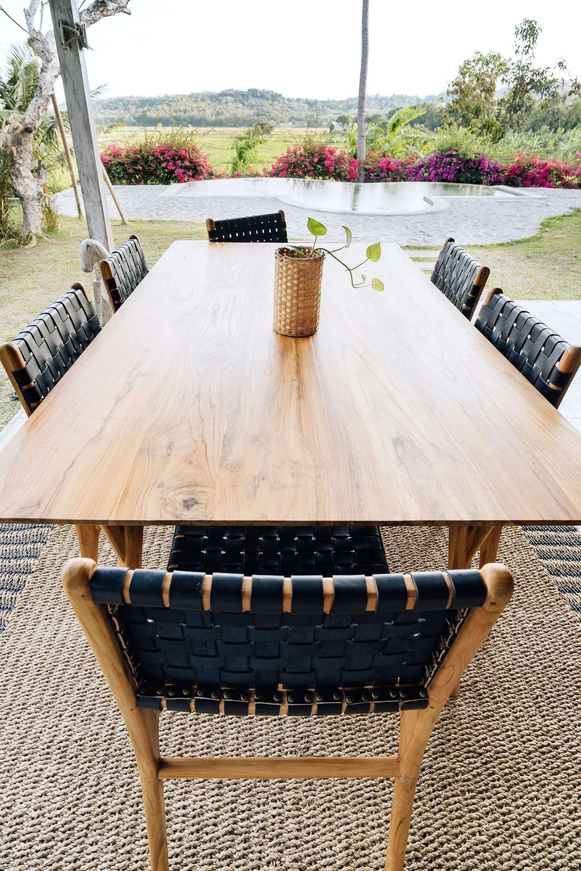 Kayu Living Umalas dining chair with hand-woven black leather seat and teak frame. Modern design, traditional craftsmanship.