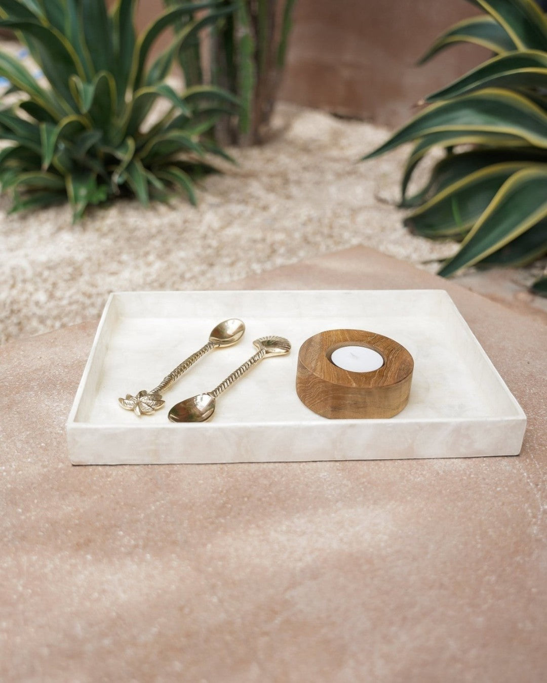 Kayu Living white rectangular Capiz shell tray holding two gold spoons and a small wooden candle holder